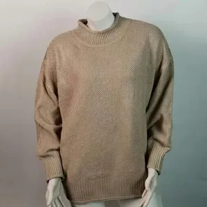 Primer plano de jersey de punto beige con cuello alto y puños acanalados