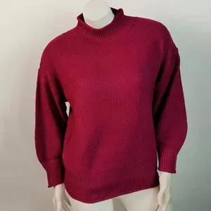 Vista detallada de un jersey de punto grueso granate con cuello alto y puños elásticos