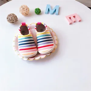 Close-up of colorful striped toddler canvas slip-on shoes on a decorative plate
