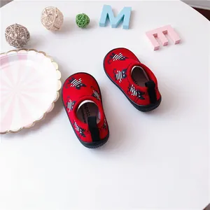 Macro view of red toddler slip-on canvas shoes featuring a cute black cat pattern