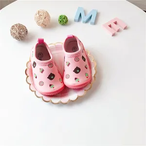 Close-up view of pink toddler walking shoes featuring adorable bear and cupcake printed patterns