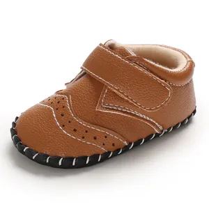 Close-up of brown baby walking shoes featuring brogue detailing and velcro strap