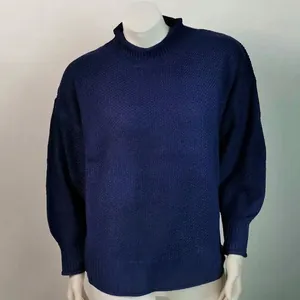 Vista detallada de un suéter de punto azul marino de cuello alto con textura de gofre