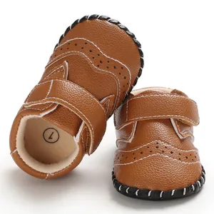 Close-up detail of brown baby walking shoes with brogue patterns and rubber sole