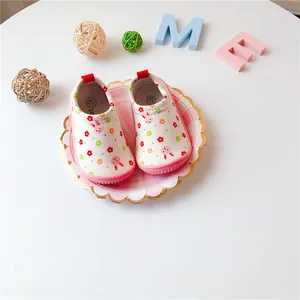 Detailed view of floral rabbit baby walking shoes on a decorative pink plate