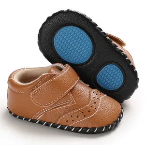 Detailed view of brown baby walking shoes with anti-slip rubber soles and white stitching.