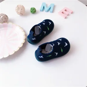 Toddler slip-on canvas shoes featuring navy blue fabric and cute white dinosaur patterns