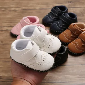 Close-up of white soft-soled baby toddler shoes with velcro strap and stitch detail
