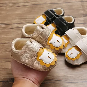 Nahaufnahme von goldenen Baby-Laufschuhen mit weichem Löwen-Cartoon-Design