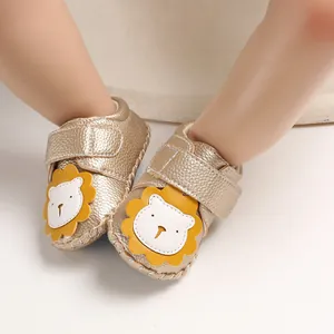 Detailansicht von goldenen Lauflernschuhen mit süßem Löwen-Patch und weicher Textur