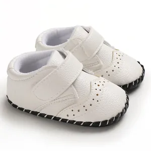 Detail view of stylish white baby walking shoes with textured faux leather and velcro straps