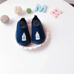 Close-up of navy blue toddler slip-on walking shoes with milk bottle pattern