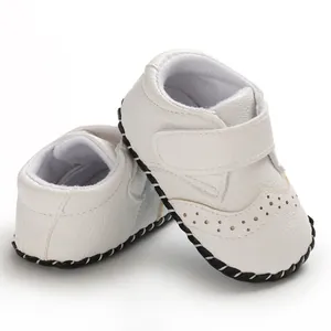 White faux leather baby walking shoes with velcro strap and non-slip rubber sole detail.