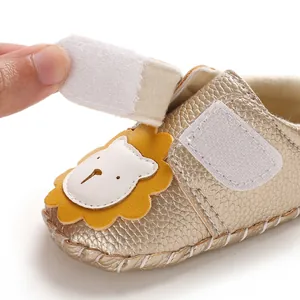 Detailansicht goldener Lauflernschuh für Babys mit süßem Löwenmotiv und Klettverschluss