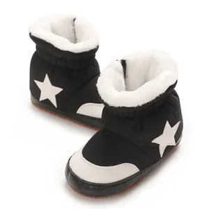 Gros plan sur la doublure épaisse en fourrure et le motif étoile des bottes bébé