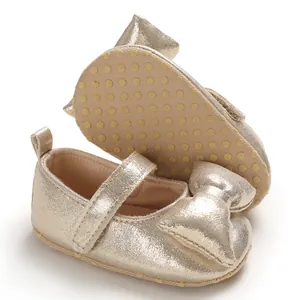 Close-up of gold baby girl princess shoes with decorative bow and anti-slip soft sole