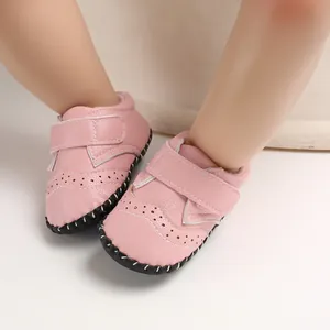 Close-up of pink baby walking shoes with anti-slip rubber soles and brogue details