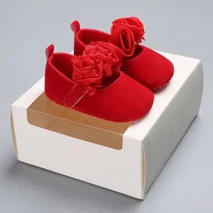 Nahaufnahme von roten Baby-Prinzessin-Schuhen mit floralen Details auf Geschenkbox