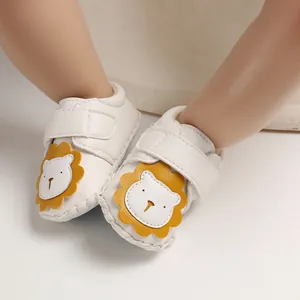 Nahaufnahme weißer Lauflernschuhe für Babys mit Löwen-Cartoon und Klettverschluss