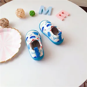 Detailed view of breathable toddler slip-on canvas shoes with cute blue whale pattern.