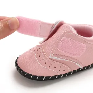 Close-up showing the easy-fasten Velcro strap on soft pink anti-slip baby walking shoes.