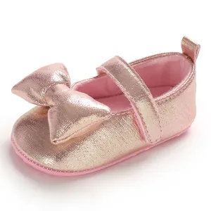 Detail showing pink metallic finish and cute bow on a soft sole baby girl princess shoe