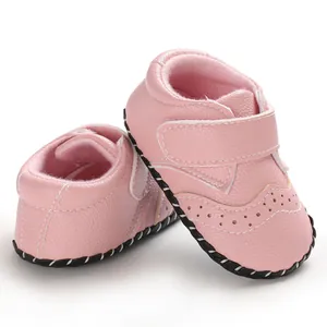 Detailed view of pink baby walking shoes featuring brogue perforations and velcro straps