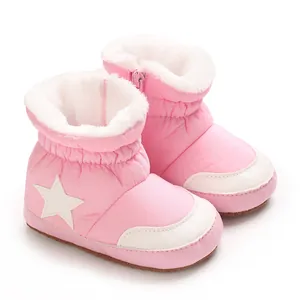 Gros plan de bottes de neige roses pour bébé avec étoile et doublure en fourrure