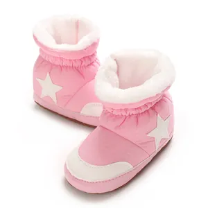 Gros plan sur des bottes de neige roses pour bébé avec étoiles blanches et fourrure