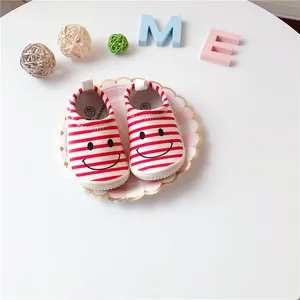 Detail view of red and white striped toddler walking shoes with a cute smiley face design