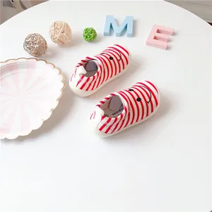 Red and white striped toddler walking shoes with a cute smiley face design on the toe