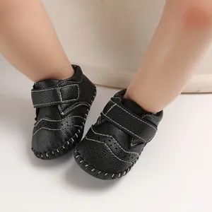Close-up view of black baby pre-walker shoes featuring white stitching and velcro straps