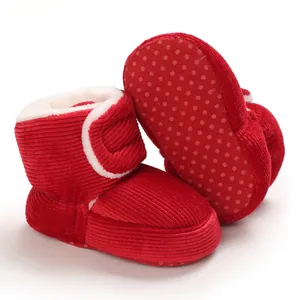 Détail des bottes bébé en velours rouge avec doublure polaire et semelle antidérapante.