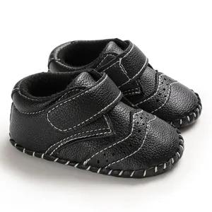 Detailed view of black infant walker shoes with white hand-stitched detailing and velcro strap