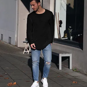 Modischer Mann im Streetstyle mit einem hochwertigen schwarzen Langarm-Strickpullover mit Rundhals