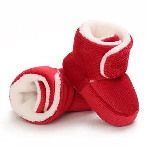 Dettaglio degli stivaletti da neonato in velluto a coste rosso con calda fodera in pile