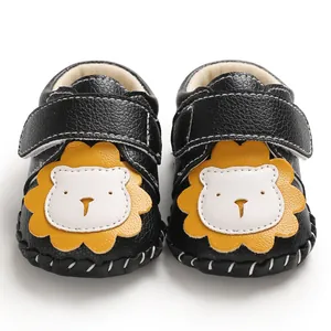 Detailansicht schwarzer Lauflernschuhe für Babys mit Löwen-Design und Klettverschluss