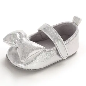 Detailed view of silver baby girl princess shoe with a large decorative bow and soft sole