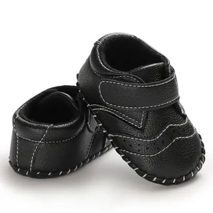 Detail shot of black baby walker shoes with white stitching and hook-and-loop straps