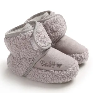 Close-up of fuzzy baby snow boots with embroidered Baby text and a heart pattern