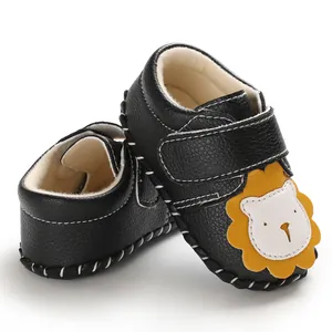 Detail der Cartoon-Löwen-Dekoration auf dem schwarzen Baby-Lauflernschuh