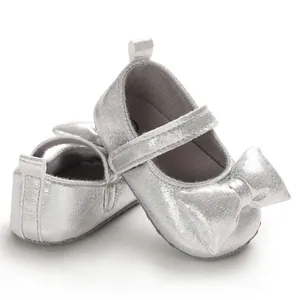 Detailed view of silver baby girl princess shoes with soft soles and large bow accent
