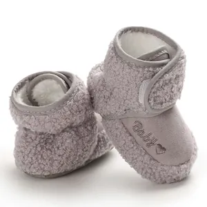 Close-up of warm grey baby snow boots with fluffy texture and embroidered Baby heart