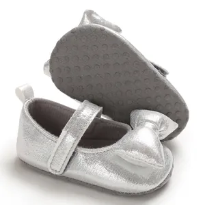 Detail of silver shimmering soft-soled baby princess shoes with non-slip dotted sole.