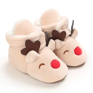 Dettaglio delle scarpine in peluche a renna per neonati con suola morbida invernale.