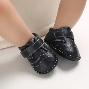 Close-up of navy blue infant walker shoes with white stitching and a secure Velcro strap.