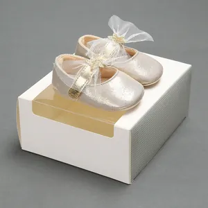 Nahaufnahme goldene Baby-Prinzessinenschuhe mit großen Netzschleifen und Sternen