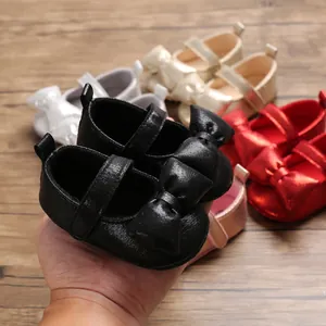 Detailed close-up of soft-sole black baby princess shoes with a large decorative bow.