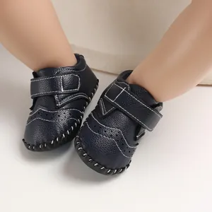 Close-up of navy blue baby pre-walker shoes with Velcro strap and white stitching.