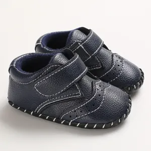 Close-up of navy blue baby walker shoes featuring textured leather and contrast stitching